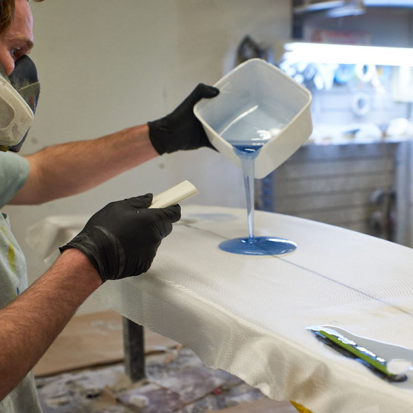 Adding resin to a surfboard repair - The Surfboard Studio